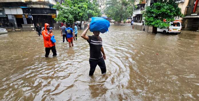 People make their way through a severely waterlogged road