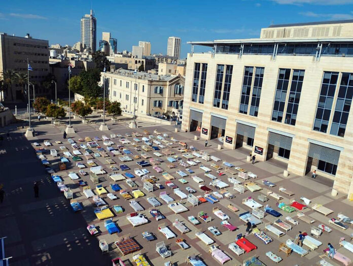 Members of Kibbutz Nir Oz set up 239 empty beds in Safra Square in Jerusalem, showcasing the number of hostages held captive by Hamas in Gaza Strip