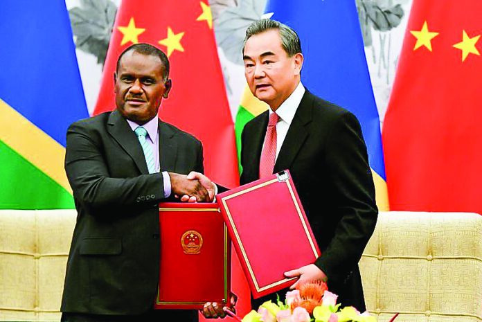 Chinese State Councilor and Foreign Minister Wang Yi shakes hands with Solomon Islands Foreign Minister Jeremiah Manele during a ceremony in Beijing_TSG