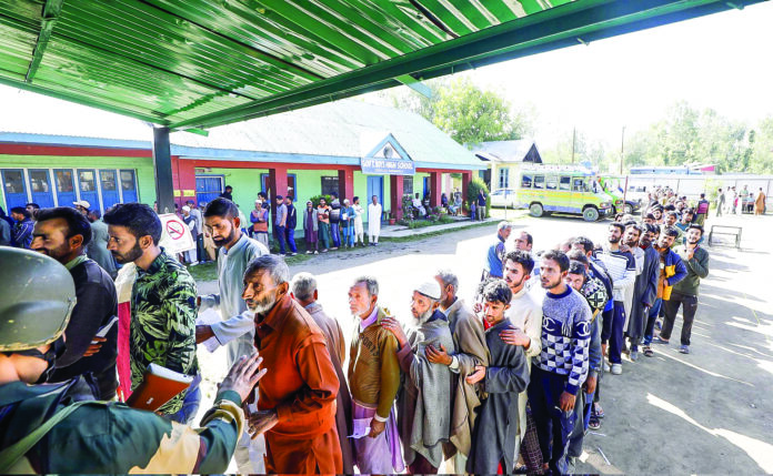 Baramulla: Voters wait in queues to cast their votes