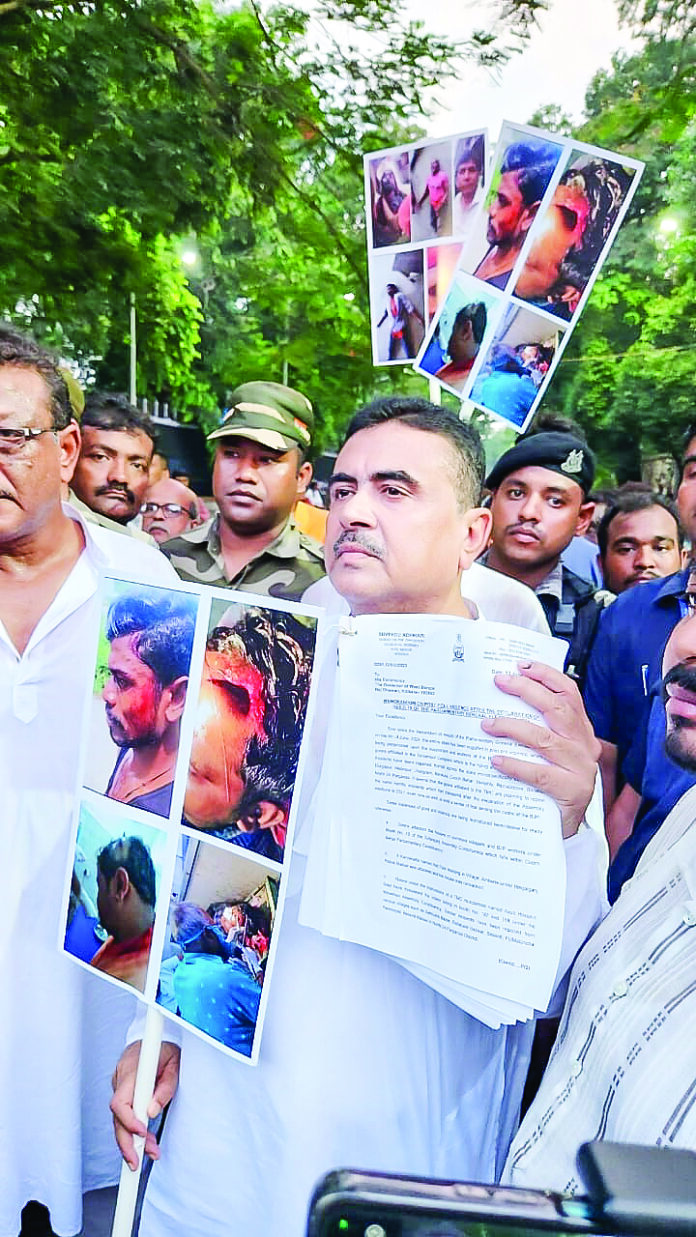 Suvendu Adhikari holds photos of victims