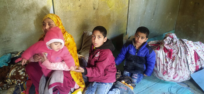 A woman with her children and baggage moves to a safe place as Doda experiences gradual sinking