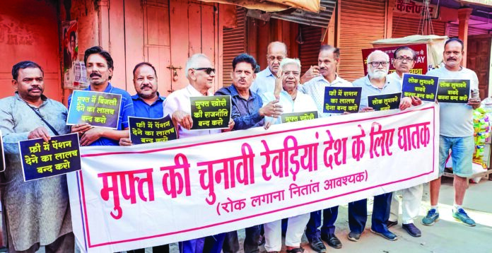Subah-e-Banaras members hold a banner as they stage a protest against the distribution of freebies by the political parties ahead of the Lok Sabha elections, in Varanasi on April 3. ANI Subah-e-Banaras members hold a banner as they stage a protest against the distribution of freebies by the political parties ahead of the Lok Sabha elections, in Varanasi on April 3. ANI