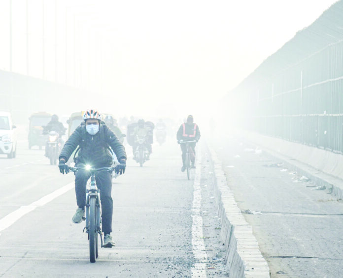 Commuters ride bicycles amid low visibility due to dense fog on a cold winter morning, in New Delhi on Saturday. (ANI) Commuters ride bicycles amid low visibility due to dense fog on a cold winter morning, in New Delhi on Saturday. (ANI)