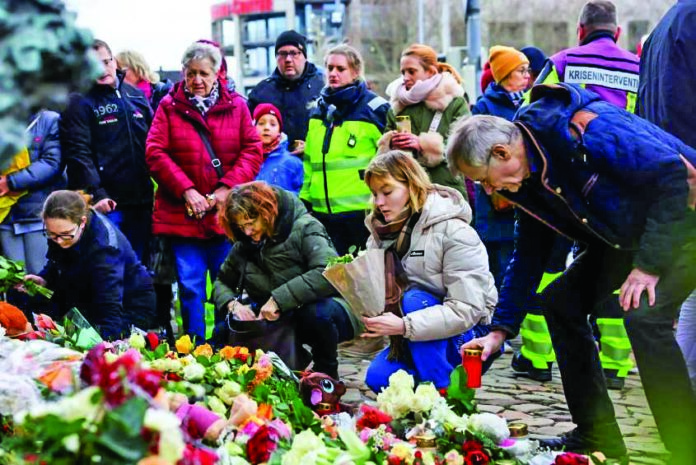 People leave candles and flowers on Saturday near the Christmas market in Magdeburg, Germany, where a Saudi Arabian man drove into a crowd, killing at least five and injuring more than 200. People leave candles and flowers on Saturday near the Christmas market in Magdeburg, Germany, where a Saudi Arabian man drove into a crowd, killing at least five and injuring more than 200.