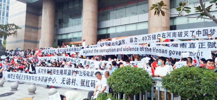 Over 3,000 Chinese demonstrators hold banners during a rare mass protest over the freezing of deposits by rural-based banks, outside a People’s Bank of China building in Zhengzhou, Henan province, China July 10, 2022. (File Photo) Over 3,000 Chinese demonstrators hold banners during a rare mass protest over the freezing of deposits by rural-based banks, outside a People’s Bank of China building in Zhengzhou, Henan province, China July 10, 2022. (File Photo)