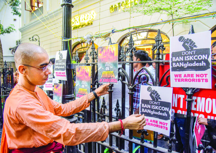 A monk puts up pamphlets outside the ISKCON headquarters against the arrest of Chinmay Prabhu by Dhaka police, in Kolkata on Thursday. ANI A monk puts up pamphlets outside the ISKCON headquarters against the arrest of Chinmay Prabhu by Dhaka police, in Kolkata on Thursday. ANI