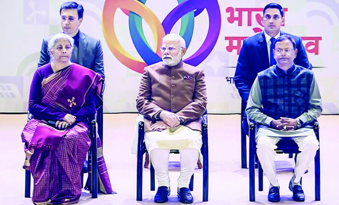 PM Narendra Modi with Union Finance Minister Nirmala Sitharaman and Union Minister of State for Finance Pankaj Chaudhary during the inauguration of Grameen Bharat Mahotsav 2025, at Bharat Mandapam in New Delhi, on January 4. (ANI) PM Narendra Modi with Union Finance Minister Nirmala Sitharaman and Union Minister of State for Finance Pankaj Chaudhary during the inauguration of Grameen Bharat Mahotsav 2025, at Bharat Mandapam in New Delhi, on January 4. (ANI)