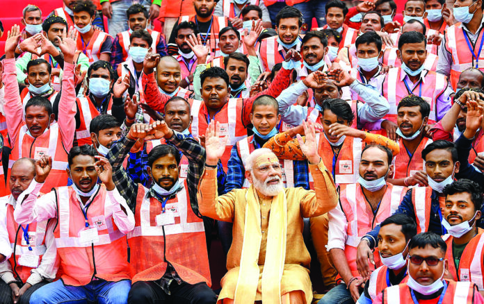Prime Minister Narendra Modi sits with the workers involved in the construction work of the Kashi Vishwanath Dham Corridor, at its inauguration, in Varanasi on 13 December 2021. ANI Prime Minister Narendra Modi sits with the workers involved in the construction work of the Kashi Vishwanath Dham Corridor, at its inauguration, in Varanasi on 13 December 2021. ANI