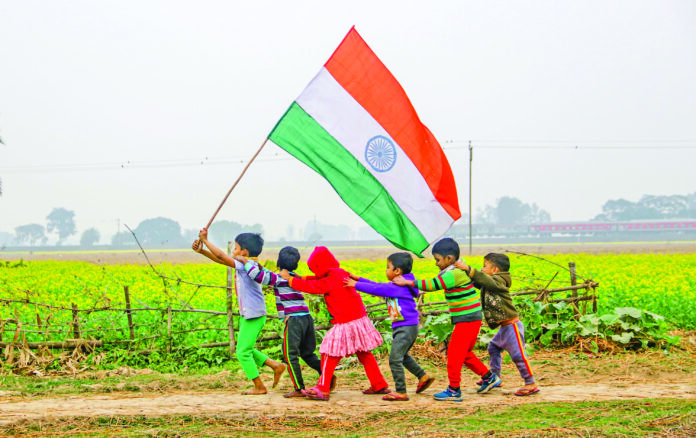 Children holding the National Flag run through a mustard field ahead of Republic Day celebrations, at a village near Balurghat in Bengal’s South Dinajpur on Saturday. ANI Children holding the National Flag run through a mustard field ahead of Republic Day celebrations, at a village near Balurghat in Bengal’s South Dinajpur on Saturday. ANI