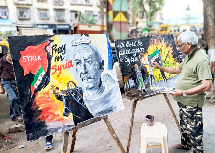 A Gurukul School of Art teacher makes paintings on the Syria issue, alongside a road, in Mumbai on 9 December. ANI A Gurukul School of Art teacher makes paintings on the Syria issue, alongside a road, in Mumbai on 9 December. ANI
