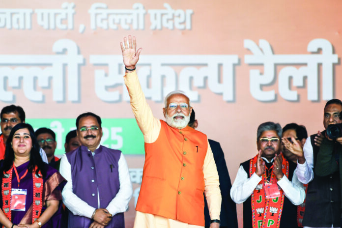 PM Narendra Modi greets the crowd at a public meeting in RK Puram, New Delhi, ahead of the Delhi Assembly elections. Delhi BJP President Virendra Sachdeva and party MP Bansuri Swaraj are also present, on February 2. ANI PM Narendra Modi greets the crowd at a public meeting in RK Puram, New Delhi, ahead of the Delhi Assembly elections. Delhi BJP President Virendra Sachdeva and party MP Bansuri Swaraj are also present, on February 2. ANI