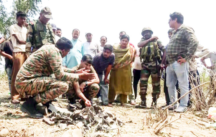 Army personnel inspect the debris of a projectile after artillery firing and shelling by Pakistan Armed Forces, at Damtal village in Kangra on Saturday. ANI Army personnel inspect the debris of a projectile after artillery firing and shelling by Pakistan Armed Forces, at Damtal village in Kangra on Saturday. ANI