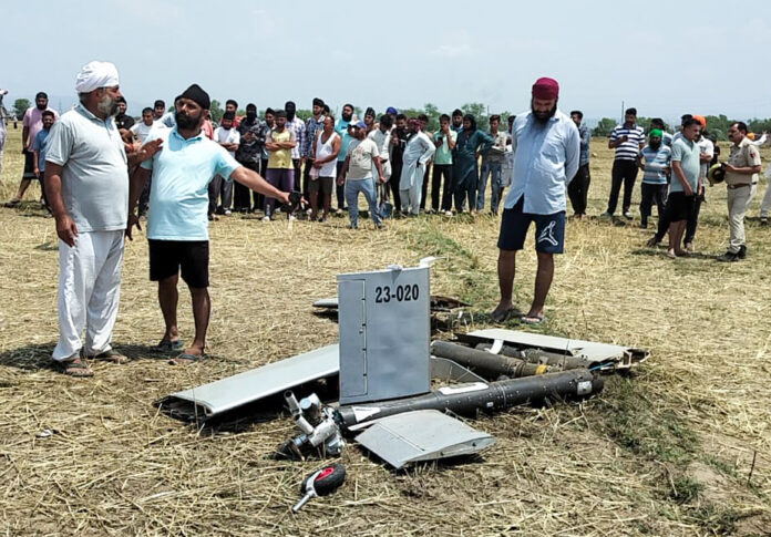 People gather near the remains of a drone debris found in an open field at Rehal village, Bishnah, in Jammu on Saturday. ANI People gather near the remains of a drone debris found in an open field at Rehal village, Bishnah, in Jammu on Saturday. ANI