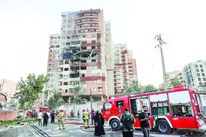 Firefighters work at the scene of a damaged building in the aftermath of Israeli strikes, in Tehran on Friday. Reuters/ANI Firefighters work at the scene of a damaged building in the aftermath of Israeli strikes, in Tehran on Friday. Reuters/ANI