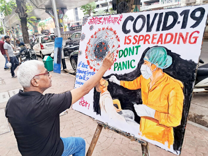 A teacher of Gurukul School of Art makes an awareness painting of Covid, in Mumbai on 21 May. ANI