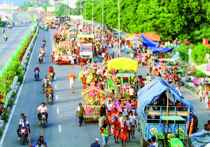Kanwariyas (Shiv devotees) carry pots filled with water collected from Ganga river during the Kanwar Yatra in the ongoing Sawan month at Delhi- Haridwar expressway